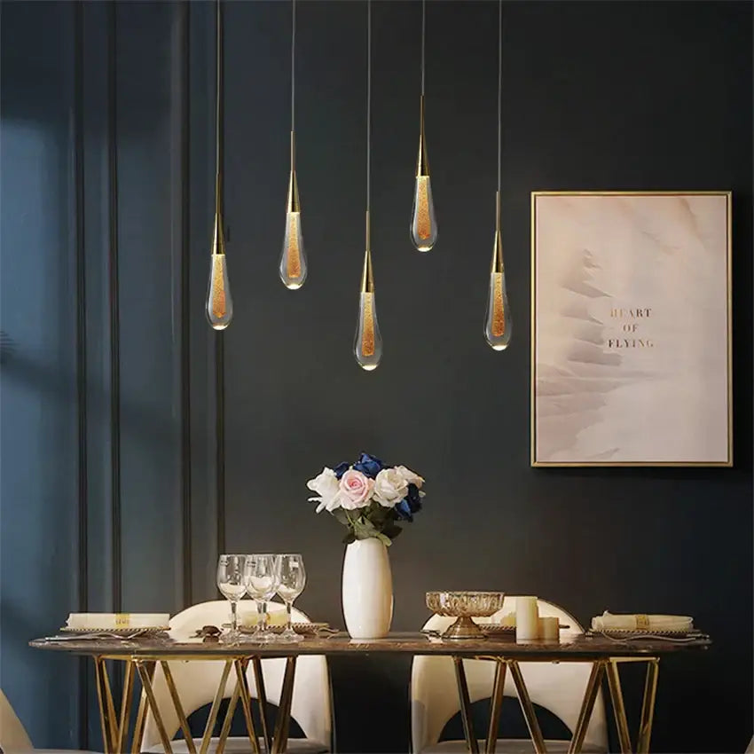 Five elegant gold pendant lights with crystal glass led shades filled with golden glitter for dining room decorbites