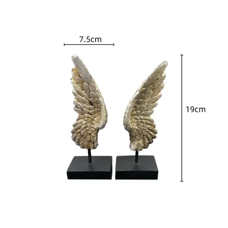 Pair of elegant metallic gold angel wings resin sculptures with detailed feather texture on black square bases for decor