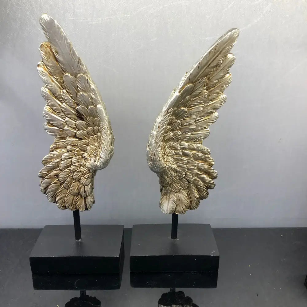 Elegant golden angel wings resin sculpture with detailed feathering mounted on black bases for living room decor