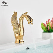 Elegant golden swan faucet with intricate wing detailing and polished metallic finish for bathroom hot and cold mixer tap