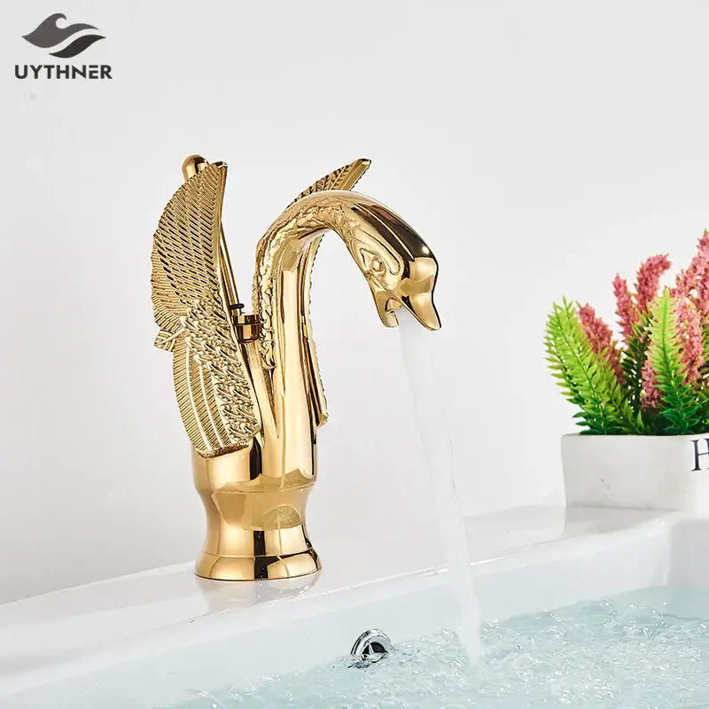 Elegant golden swan faucet with intricate wing detailing and polished metallic finish for bathroom hot and cold mixer tap