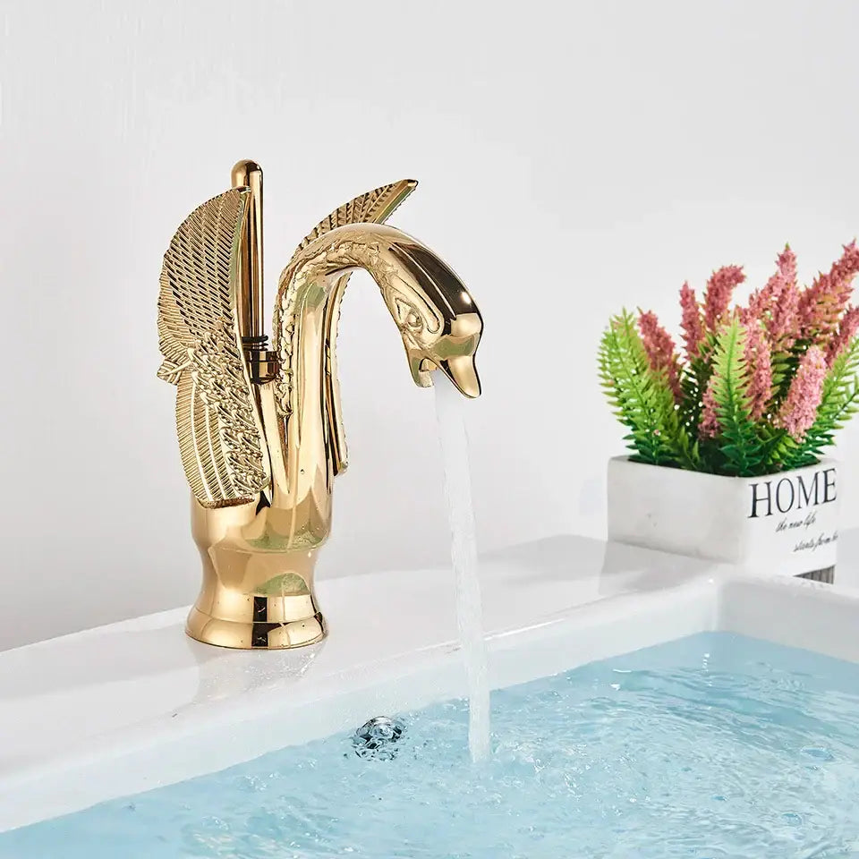 Elegant golden swan faucet with detailed feathered wings and polished metallic finish for bathroom hot and cold mixer tap