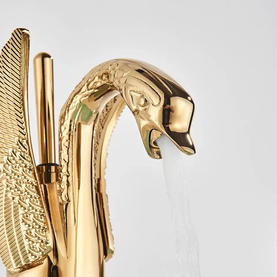 Elegant golden swan faucet with intricate feather detailing and polished metallic finish for bathroom mixer tap