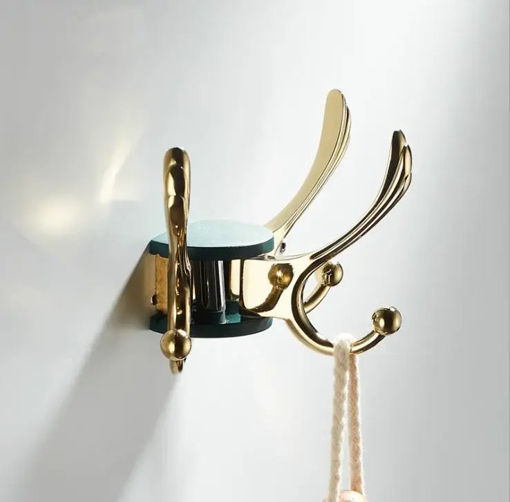 Elegant green gold zinc alloy wall-mounted coat hook with sleek modern design and three curved hooks for bathroom use