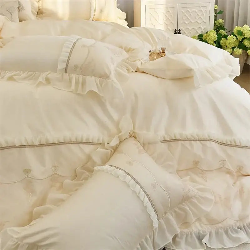 Cream-colored satin bedding set with elegant heart embroidery ruffles and subtle gray piping by decorbites elegant heart