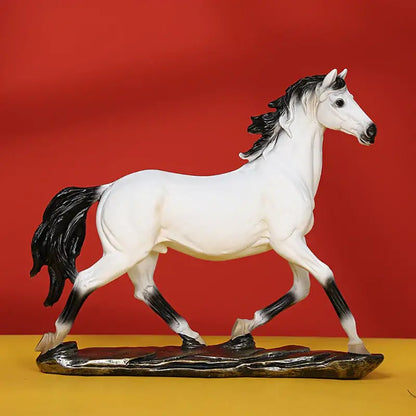 A sleek white elegant horse resin statue with black mane and tail standing on a dark textured base for living room decor