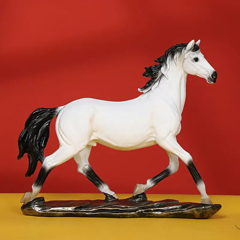A sleek white elegant horse resin statue with black mane and tail standing on a dark textured base for living room decor