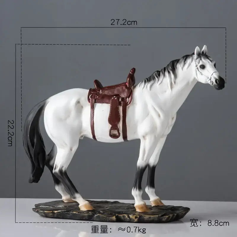 Elegant horse resin statue featuring a white and black horse with a brown saddle on a rocky base for living room decor