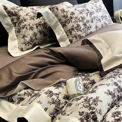 Cream-colored satin pillowcases with dark brown floral embroidery and piping in elegant egyptian cotton bedding sets