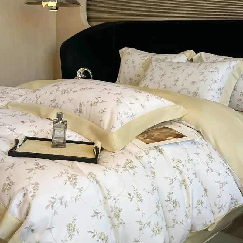 Elegant ivory bedding set with white satin eucalyptus fiber featuring gray and pale yellow floral embroidery and cream piping