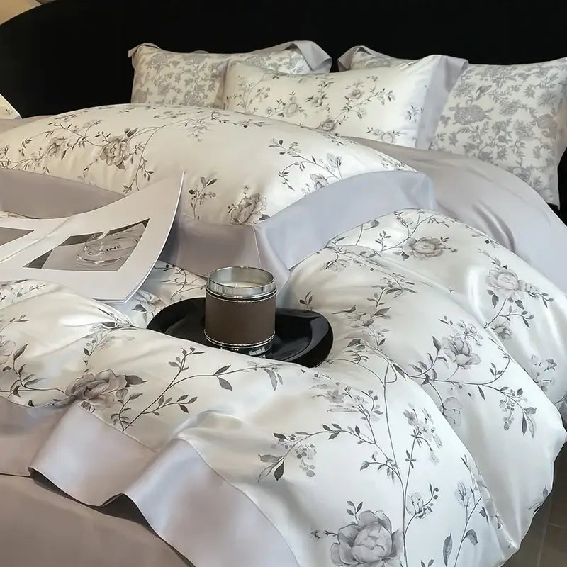 Elegant white satin bedding set with gray floral embroidery and ruffled edges made from eucalyptus fiber by decorbites