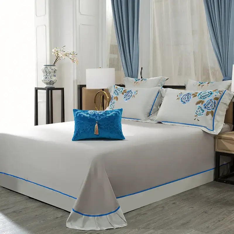 Blue velvet pillow with embroidered floral design and tassel accent from elegant ivory and royal blue 200s embroidery egyptian cotton bedding set