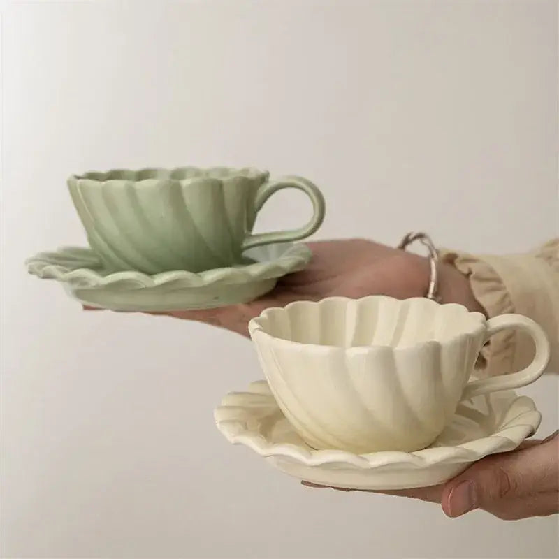 Elegant lace ceramic coffee cup and saucer set in pastel green and cream porcelain with scalloped rim for dining room use