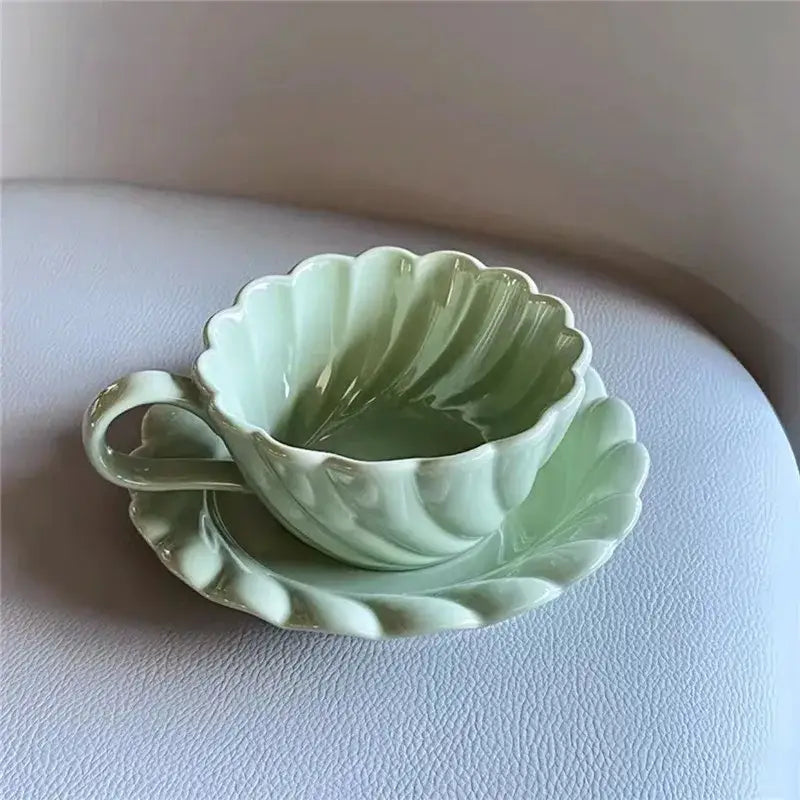 Elegant lace ceramic coffee cup and mint green saucer set with scalloped edge and vertical ridges for dining room use