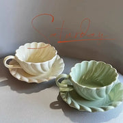 Elegant lace ceramic coffee cup and saucer set in white and mint green with scalloped shell design for dining room
