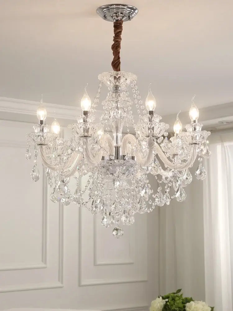 Elegant led crystal chandelier with multiple arms and hanging droplets suspended by twisted brown cord in dining room