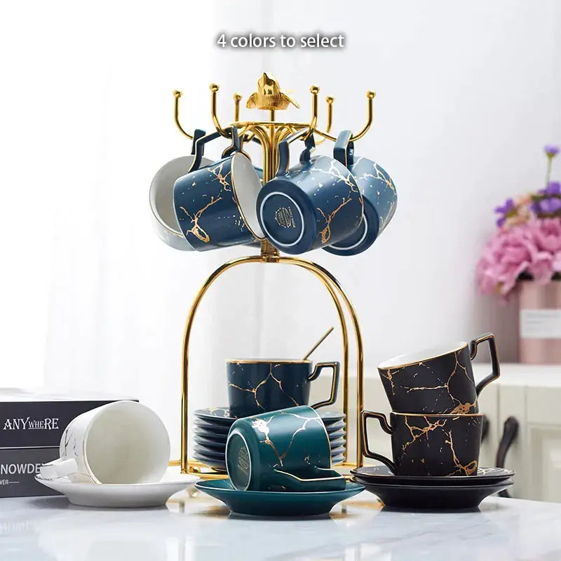 Elegant marble ceramic tea set featuring gold-marbled navy blue black and teal mugs with matching saucers on a gold rack