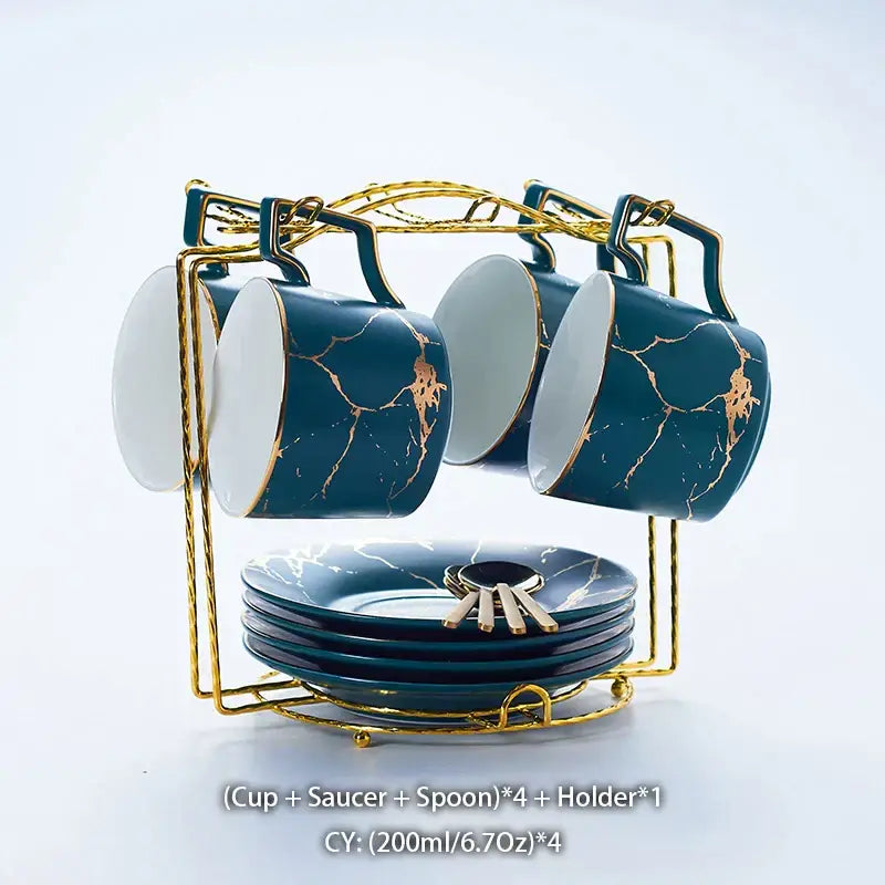 Set of four navy blue ceramic tea set mugs with gold marble crackle design and white interiors on golden rack