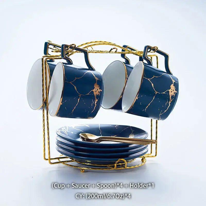 Set of four navy blue marble ceramic tea set cups with gold crackle glaze and saucers on a gold metal rack