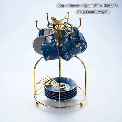 Elegant navy blue marble ceramic tea set with gold veining includes cups, saucers, and spoons on a golden stand