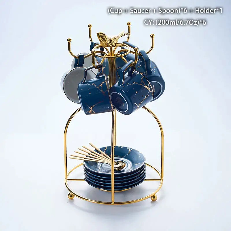 Elegant navy blue marble ceramic tea set with gold veining includes cups, saucers, and spoons on a golden stand