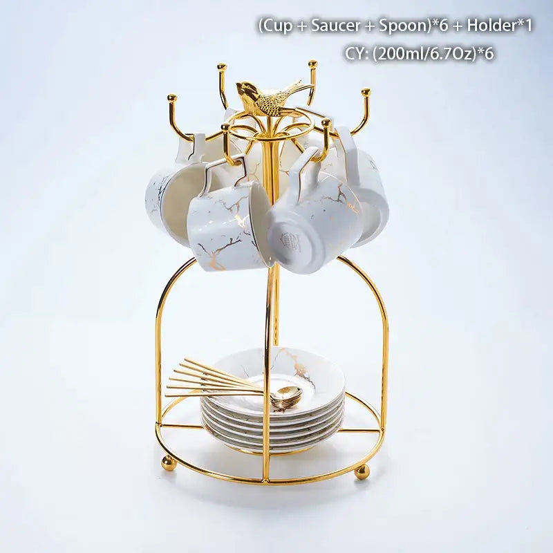Gold-toned metal cup rack with six white marble ceramic tea cups saucers and spoons in elegant ceramic tea set design