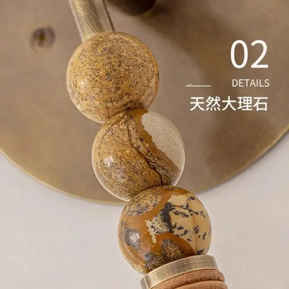 Natural marble beads with earthy brown beige and black veining featured in decorbites elegant marble copper wall lamp