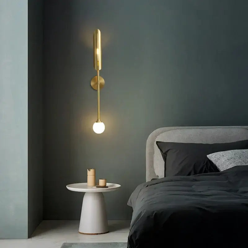 Gold-toned decorbites elegant modern wall lamp with a sleek cylindrical body and frosted glass bulb for bedroom decor