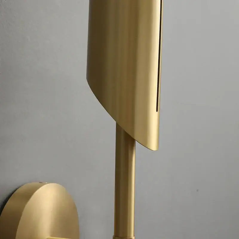 Elegant modern wall lamp with gold finish, sleek curved shade, cylindrical stem, and frosted glass bulb for bedroom decorbites elegant modern use