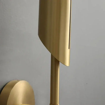 Elegant modern wall lamp with gold finish, sleek curved shade, cylindrical stem, and frosted glass bulb for bedroom decorbites elegant modern use