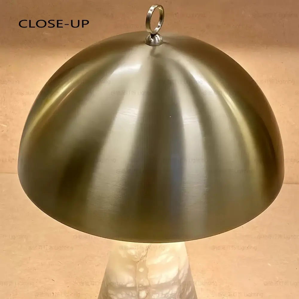 Elegant natural marble table lamp with a brushed brass dome-shaped lampshade and polished metallic ring by decorbites