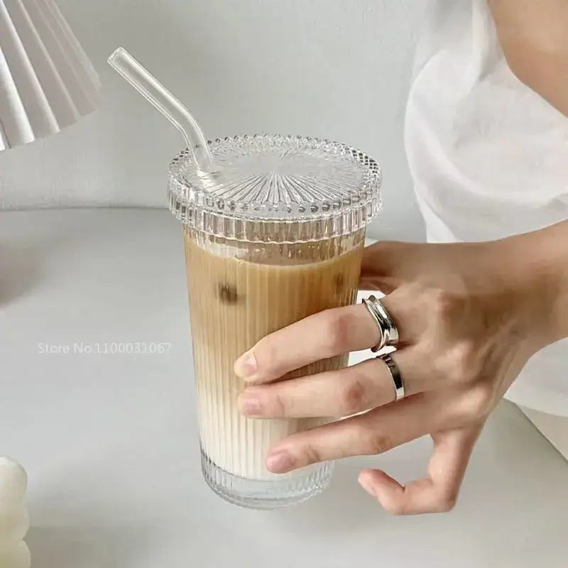 Elegant ribbed glass straw cup by decorbites glass filled with iced coffee featuring a matching clear lid