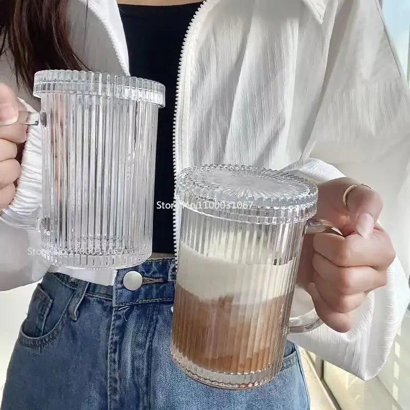 Elegant clear ribbed glass straw cup with matching lids and handles featuring a layered drink by decorbites glass
