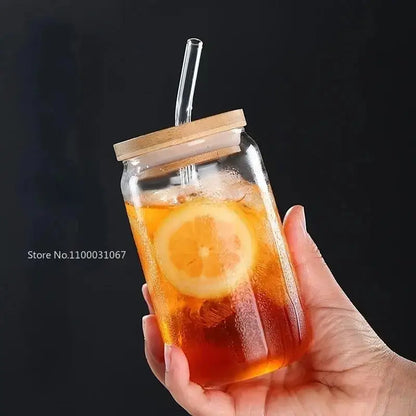 Elegant ribbed decorbites glass straw cup made of clear glass with bamboo lid and straw filled with iced tea and lemon slices