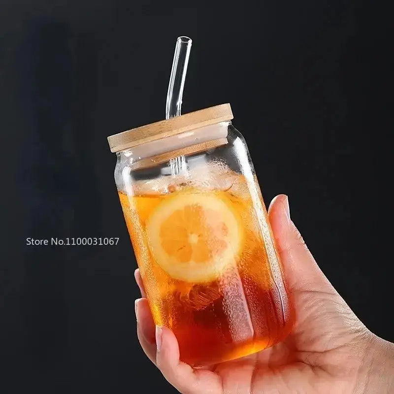 Elegant ribbed decorbites glass straw cup made of clear glass with bamboo lid and straw filled with iced tea and lemon slices
