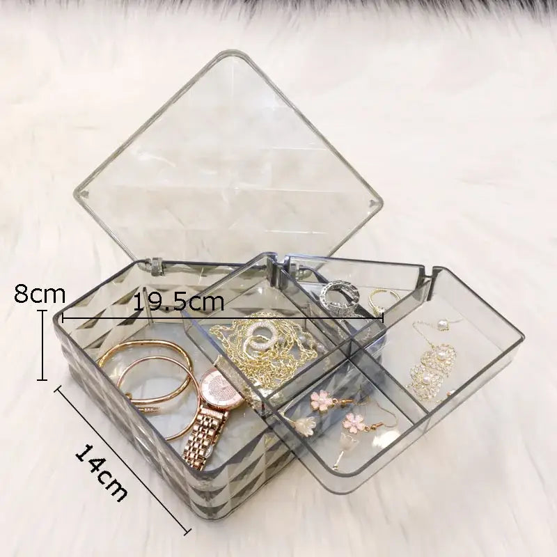 Clear acrylic jewelry organizer with geometric base and divided compartments for elegant rose gold and silver jewelry boxes