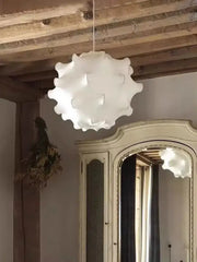 A white elegant silk pendant lamp with ruffled petal design hanging in a living room by decorbites elegant silk pendant
