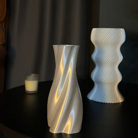A sleek silver-toned vase with a smooth twisted flowing design for decorbites elegant high-end living room decor