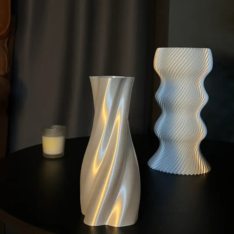 A sleek silver-toned vase with a smooth twisted flowing design for decorbites elegant high-end living room decor
