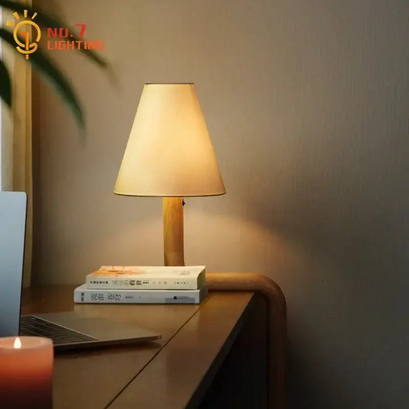 Elegant solid wood table lamp with warm-toned fabric lampshade on a slender wooden base for bedroom decorbites decor