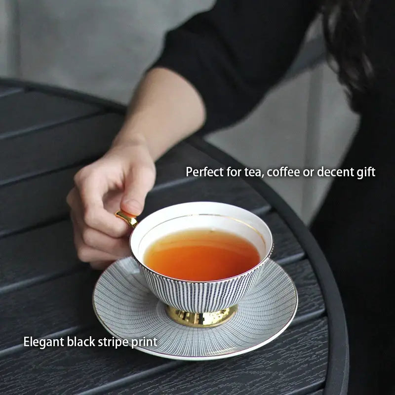 A white ceramic tea cup set with gold trim and elegant black stripes for sophisticated dining room use