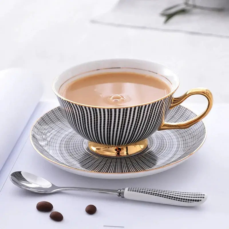 Elegant black and white striped porcelain tea cup with gold trim filled with tea from a tea cup set