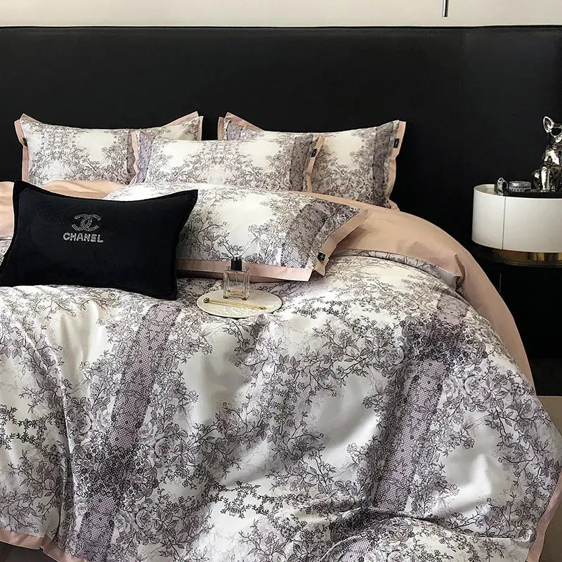 Chanel black embroidered pillow with silver logo on bed dressed in luxury teal and gold floral bedding set