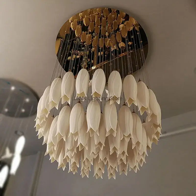Elegant tulip staircase chandelier with cream-colored frosted glass petals and gold-toned circular ceiling mount by decorbites