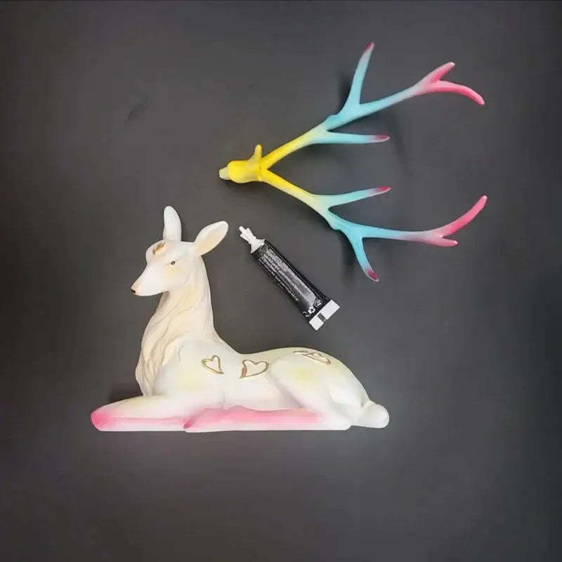 Elegant white and gold elk figurine with pastel gradient antlers in yellow blue and pink hues decorbites deer sculpture