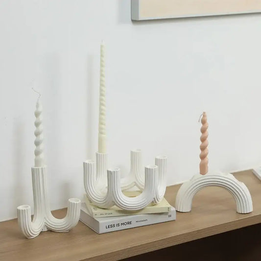Elegant white ceramic candlestick holder with curved ribbed design and spiral-topped candles for dining room decorbites decor