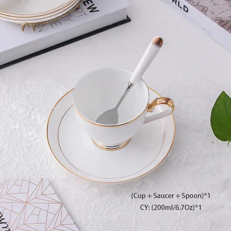 Elegant white and gold bone china coffee set with a teacup, matching saucer, and rose gold tipped spoon