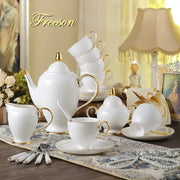 Elegant white and gold bone china coffee set with curved handles including sugar bowl creamer and stacked cups