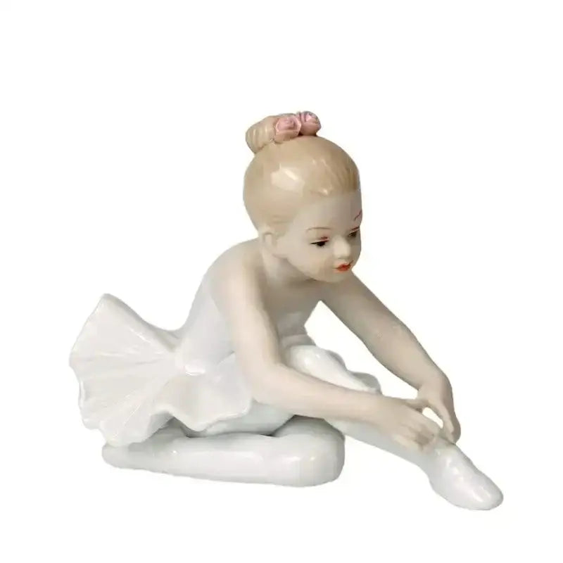 A delicate white porcelain ballet girl figurine with blonde hair in a bun and a pink flower for bedroom decor