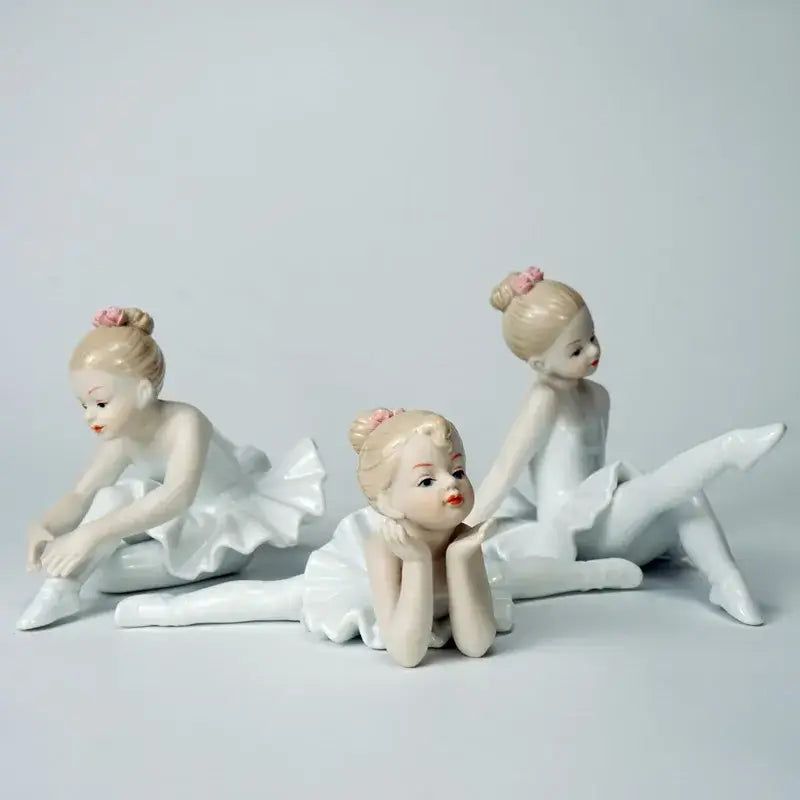 Elegant white porcelain ballet girl figurine set featuring three delicate ballet girl figurines with pink flower buns